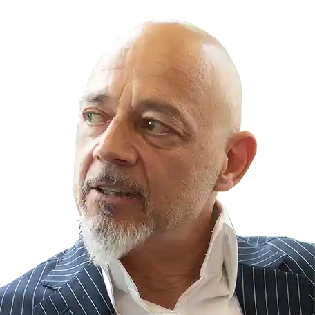 eleftherios-pursanidis-fuehrung-klarheit-wirksamkeit-wertschaetzung Eleftherios Pursanidis, blau gestreifter Anzug, glatze und weißer Bart, schaut nach rechts in einer nachdenklichen Pose.